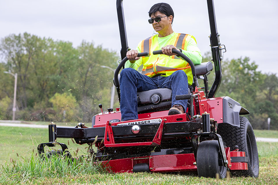 Guy on a Country Clipper Charger commercial grade zero-turn mower.