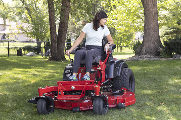 Woman mowing on a Country Clipper XLT residential grade zero-turn mower with joystick steering.