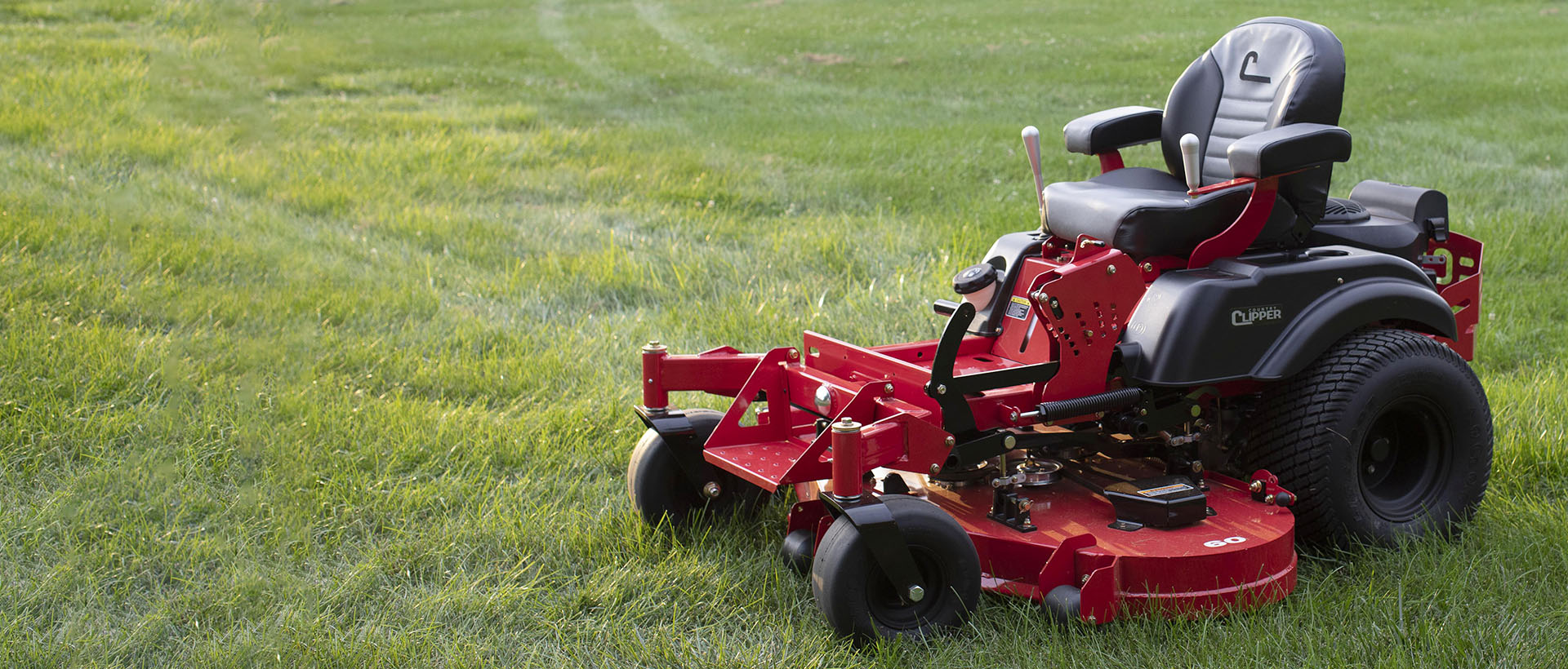 Country Clipper zero-turn mower with joystick steering in a grass field.